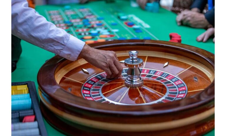 How do baccarat tables communicate tie bet settlement?